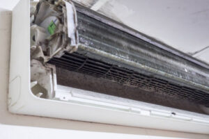 Open indoor air conditioner open to show dirt and debris inside