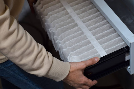 Hands holding furnace air filter